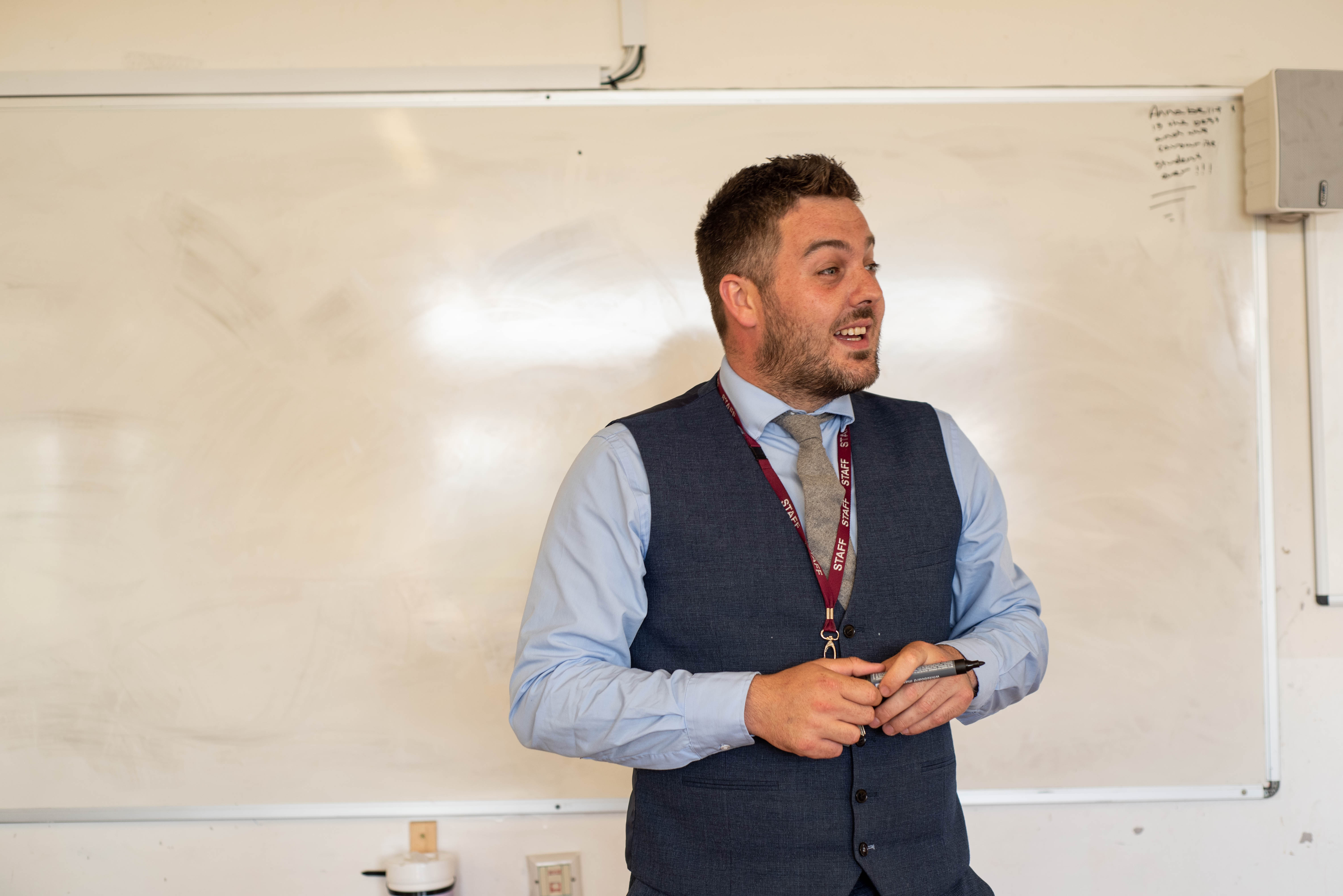 Teacher talking at the front of a classroom